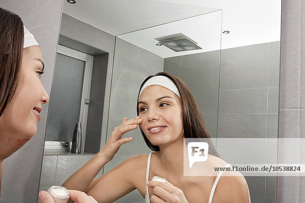 Woman examining her face in mirror