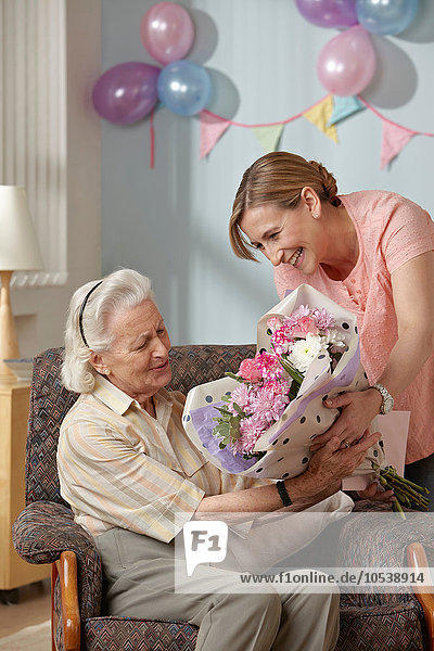 Tochter schenkt Senior-Mutter Blumenstrauß
