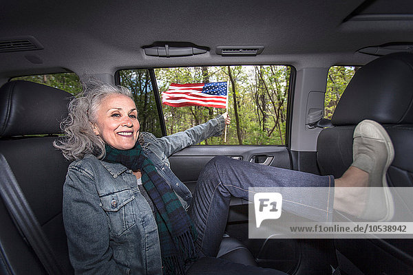 Senior woman relaxing in backseat of car  portrait