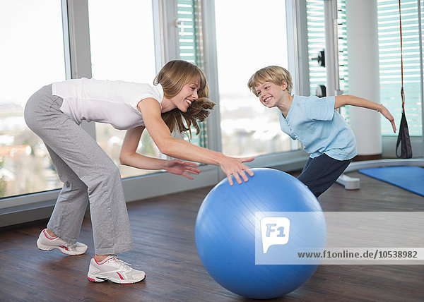 Mutter und Sohn spielen im Fitnessstudio