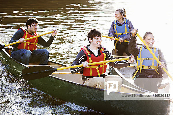 Freunde rudern Kanus auf dem stillen See