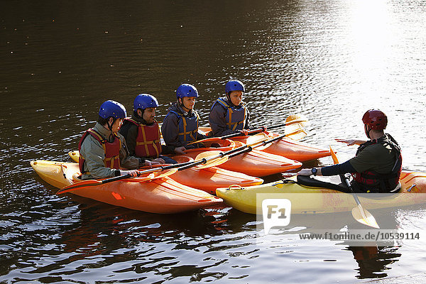 Teacher talking to students in kayaks
