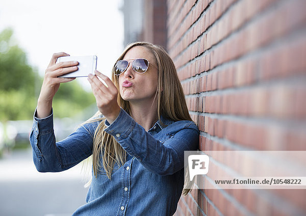 Junge blonde Frau macht Selfie