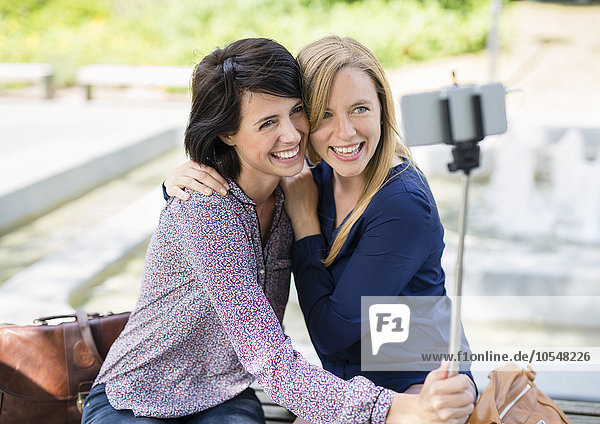 Zwei junge Frauen machen Selfie mit Handstativ