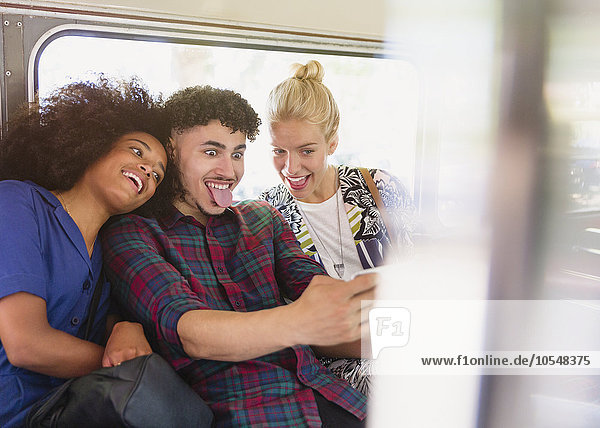 Verspielte Freunde, die im Bus Gesichter machen.