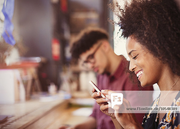 Lächelnde Frau SMS mit Handy