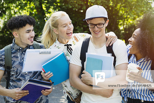 Enthusiastische Studenten scherzen mit Freunden draußen