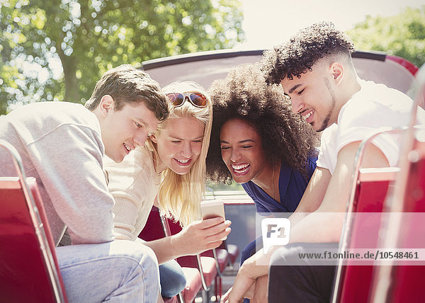Freunde SMS mit Handy im Doppeldeckerbus