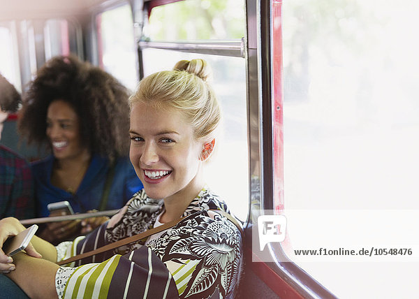Portrait lächelnde blonde Frau beim Busfahren