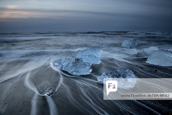 Lange Exposition von Eis am kalten,  stürmischen Meeresstrand,  Jokulsarlon,  Island