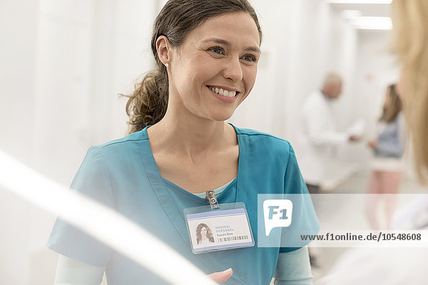 Lächelnde Krankenschwester im Gespräch mit dem Arzt im Krankenhausflur