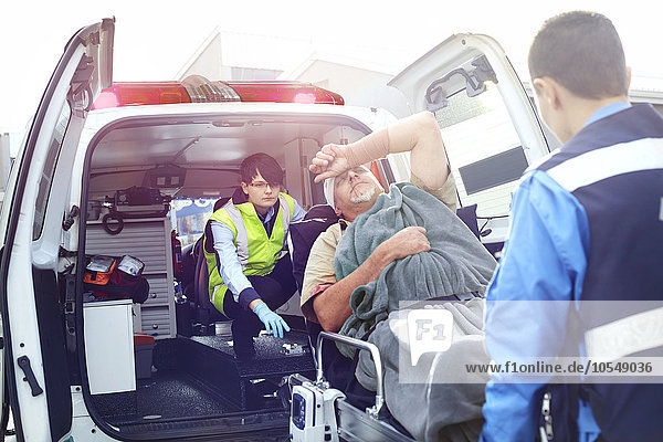 Rettungskräfte beim Verladen des Unfallopfers in den Krankenwagen