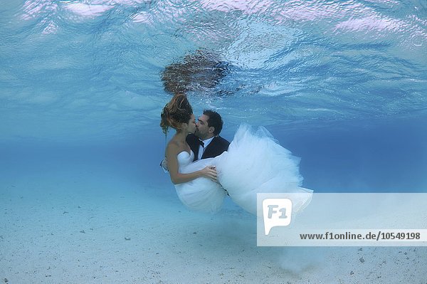 Jungvermählte küssen sich unter Wasser  Indischer Ozean  Malediven  Asien