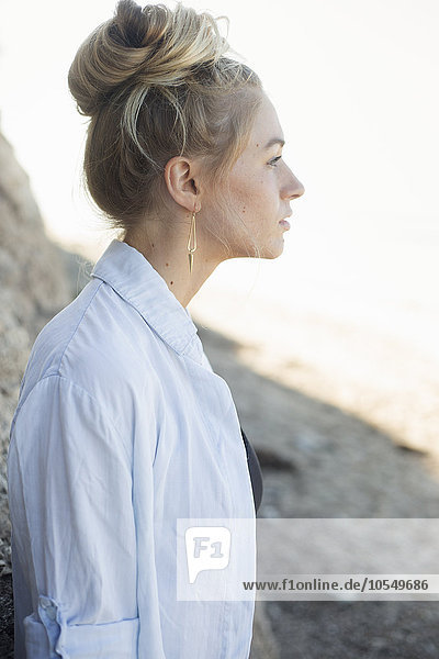 Profile portrait of a blond woman with a hair bun.