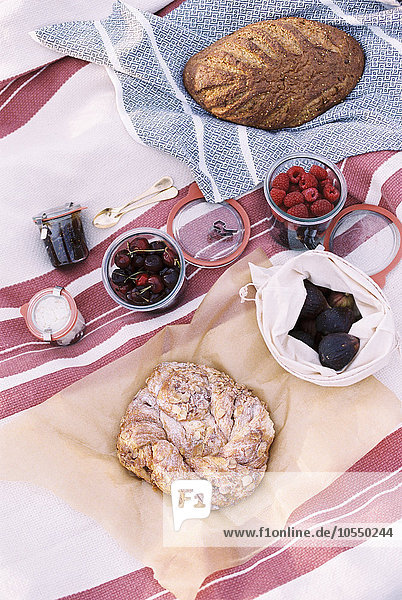 High angle view of food on a picnic blanket  breads and fruits.