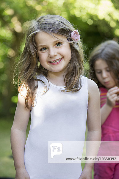 Zwei lächelnde junge Mädchen bei einer Gartenparty.