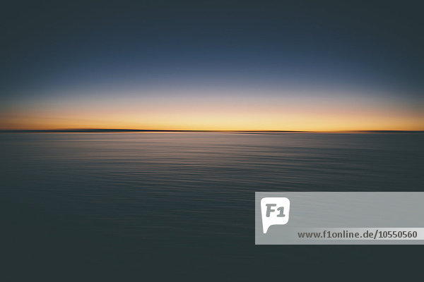 Der Blick über die Oberfläche der Bonneville Salt Flats auf das Licht der Morgendämmerung bei Sonnenaufgang.