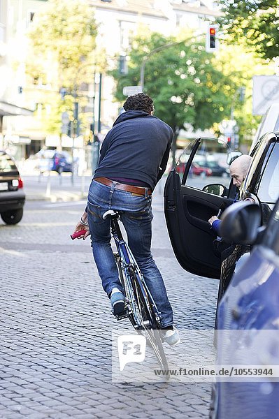 Radfahrer in der Stadt  Gefahr durch geöffnete Autotüre  Fahrrad muss ausweichen  Deutschland  Europa