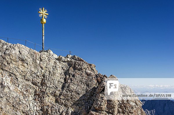 Vergoldetes Gipfelkreuz am Gipfel der Zugspitze  hinten Ausblick nach Tirol  Garmisch-Partenkirchen  Wettersteingebirge  Ostalpen  Oberbayern  Bayern  Deutschland  Europa