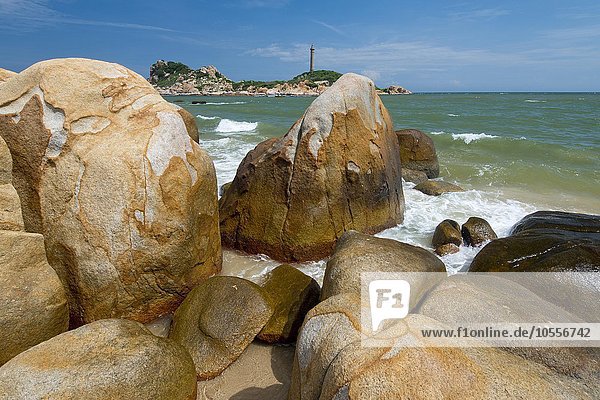 Meeresbrandung an den Sandsteinen in der Bucht von Ke Ga  hinten höchster und ältester Leuchtturm in Vietnam  Phan Thiet  Ke Ga  Vietnam  Asien