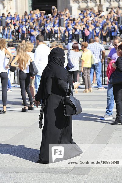 Orientalische Frau  gekleidet in schwarzer Burka  Menschenmenge  Piazza del Duomo  Mailand  Lombardei  Italien  Europa