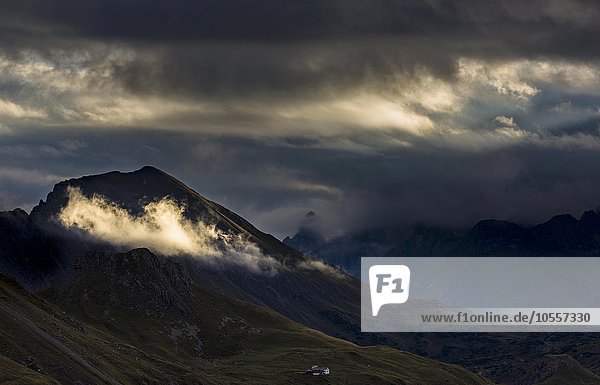 Clouds with sunny spot in front of dark mountain peaks  Allgäu Alps  Warth  Vorarlberg  Austria  Europe