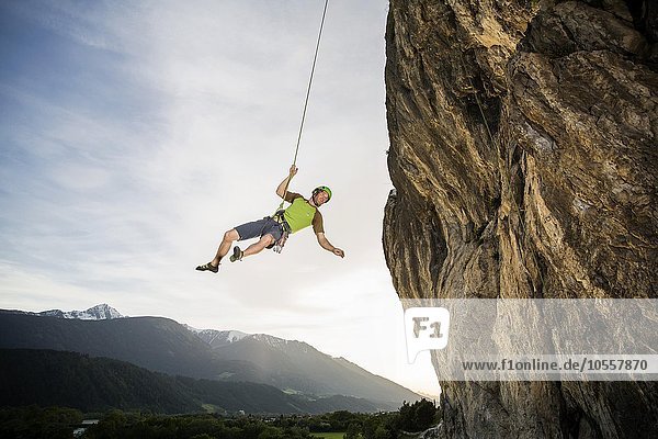 Kletterer schwingt im Seil an der Felswand entlang  Martinswand  Zirl  Tirol  Österreich  Europa