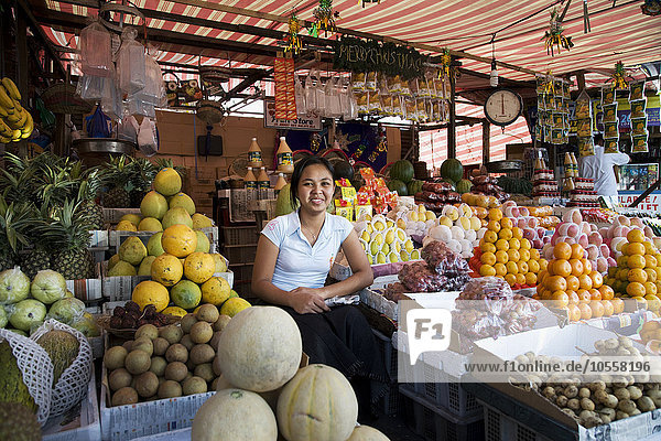 Lächelnder asiatischer Verkäufer auf dem Markt