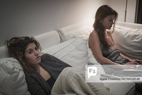 Kaukasische Frauen sitzen nachts auf dem Sofa
