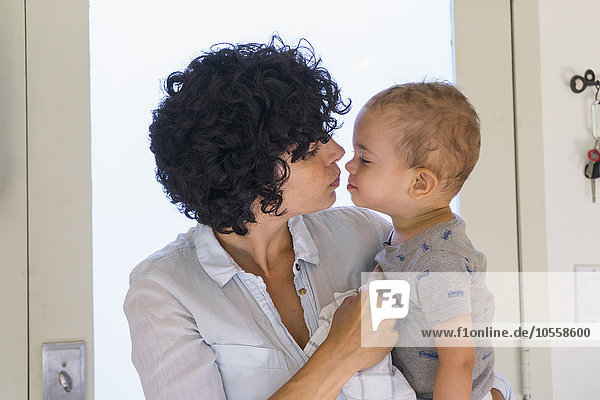 Kaukasische Mutter küsst ihren kleinen Sohn