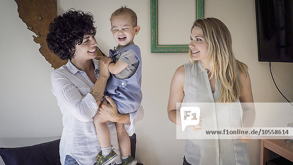 Caucasian lesbian mothers and baby son in living room