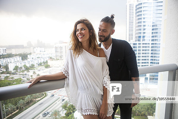 Hispanic couple standing on urban balcony