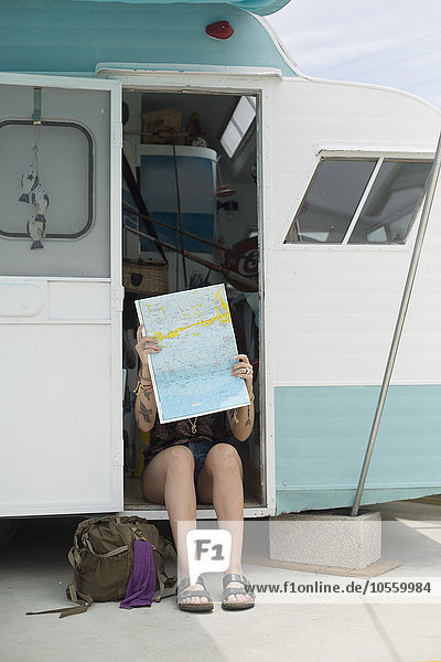 Kaukasische Frau liest Karte im Wohnwagen