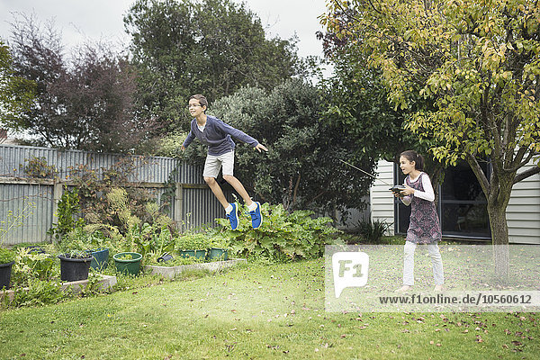 Gemischtrassige Kinder spielen mit Schwebespielzeug im Hinterhof