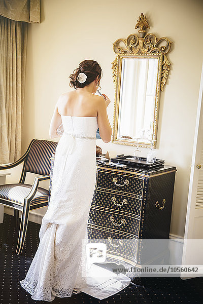 Kaukasische Braut beim Schminken im Spiegel