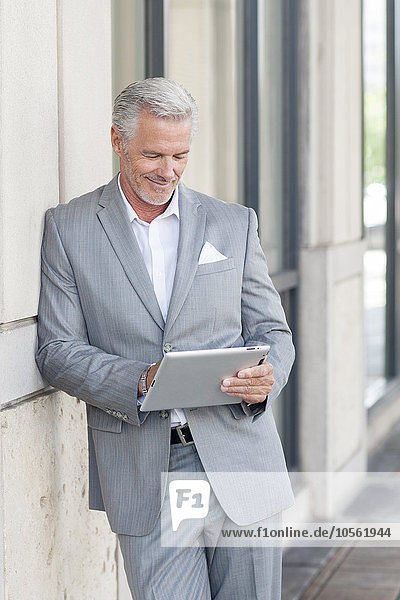 Caucasian businessman using digital tablet in city