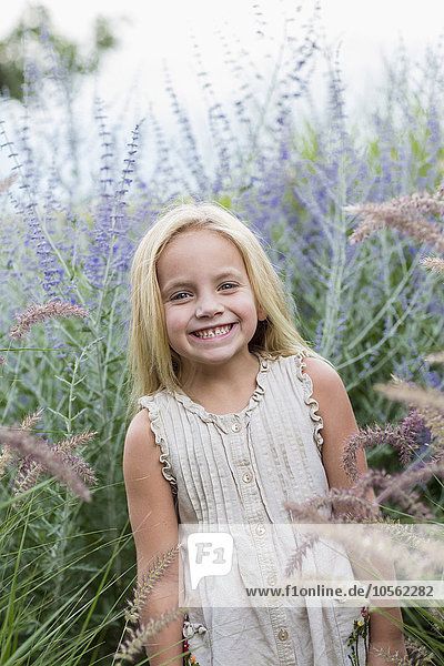 Caucasian girl standing in tall flowers