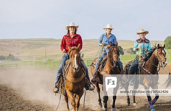 Cowgirls reiten Pferde auf Ranch