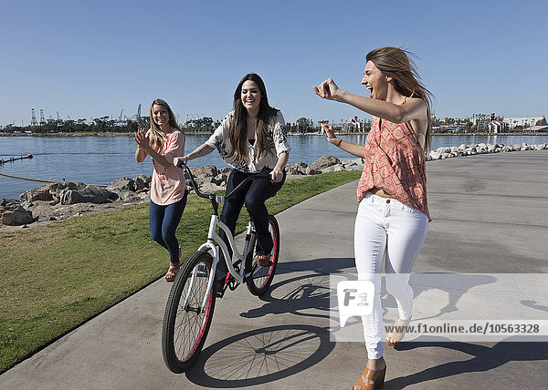 Frauen beim Laufen und Radfahren am Wasser
