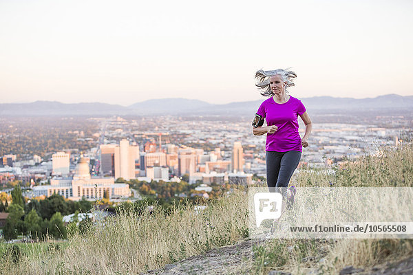Caucasian woman running on hilltop over Salt Lake City  Utah  United States