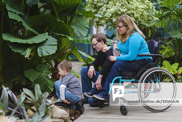 Paraplegic woman and family admiring plants