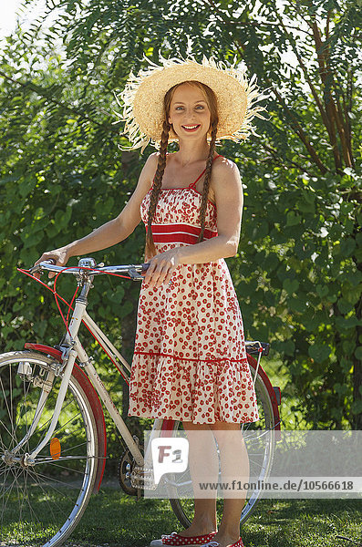 Caucasian woman standing with bicycle