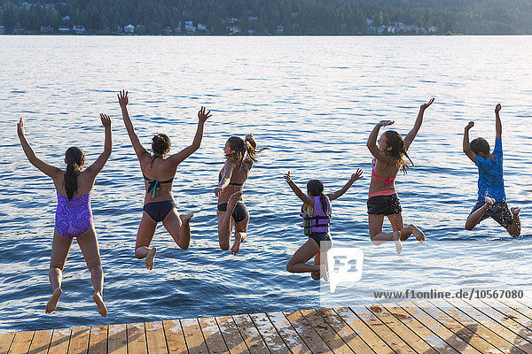 Children jumping into lake