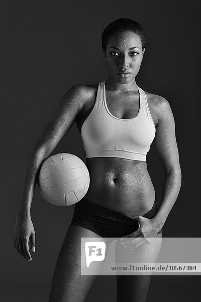 Afroamerikanische Frau hält Volleyball