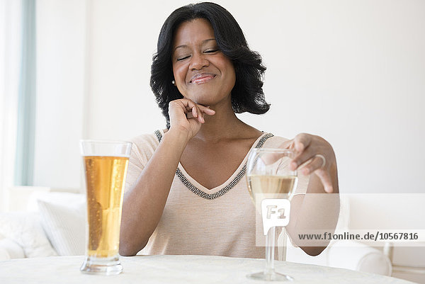 Black woman choosing between white wine and beer