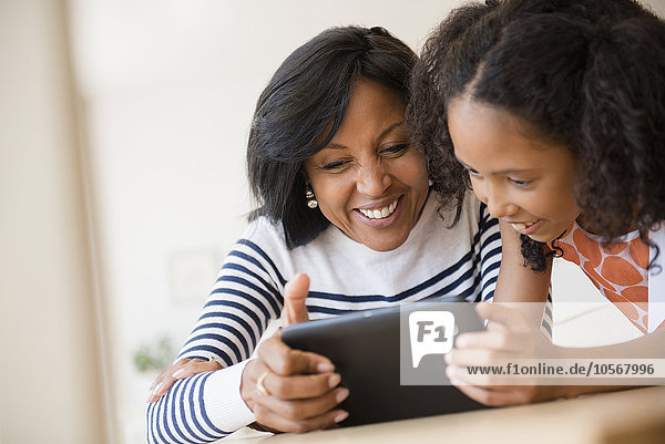 Mutter und Tochter benutzen ein digitales Tablet