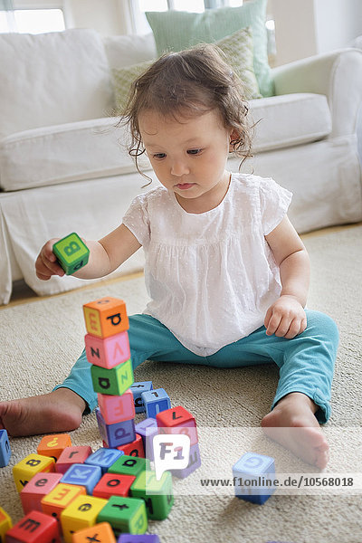 Mixed race baby girl playing with blocks