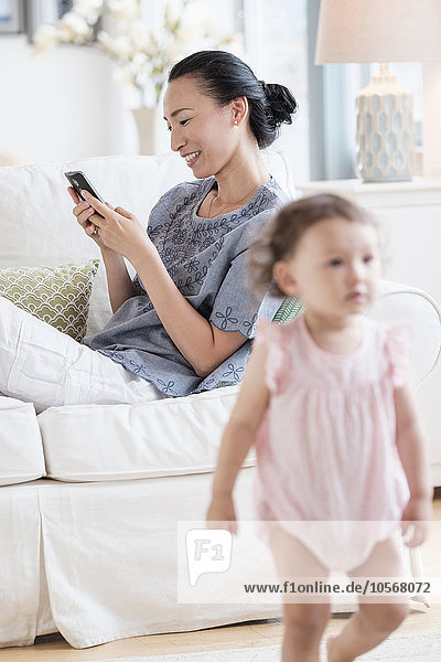 Mother with cell phone ignoring baby daughter
