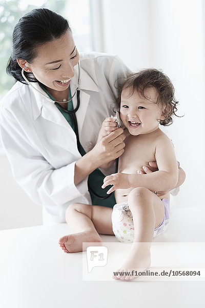 Arzt und kleines Mädchen spielen mit Stethoskop