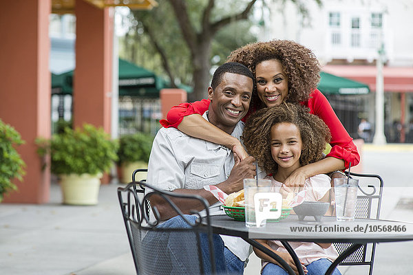 Lächelnde Familie am Tisch eines Restaurants im Freien
